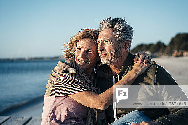 Happy mature couple spending time together at beach on sunny day