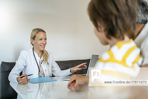 Female doctor with father and son in medical practice