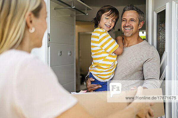 Happy man with son receiving parcel at the front door
