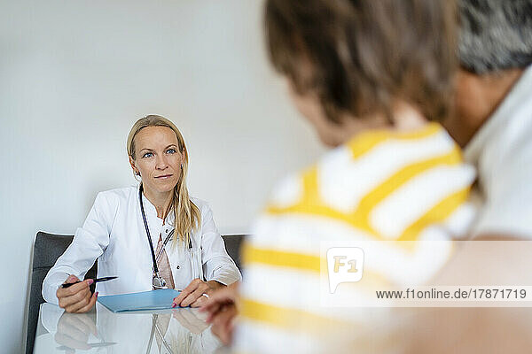 Female doctor with father and son in medical practice