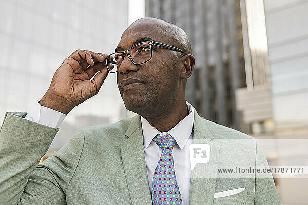 Reifer Geschäftsmann mit Brille im Finanzviertel