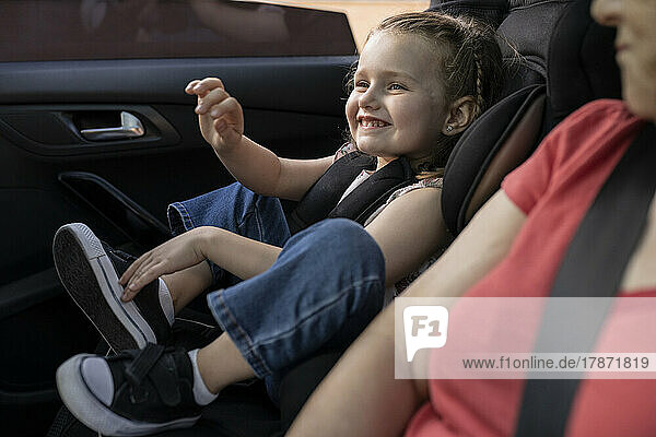 Smiling girl sitting with grandmother in car