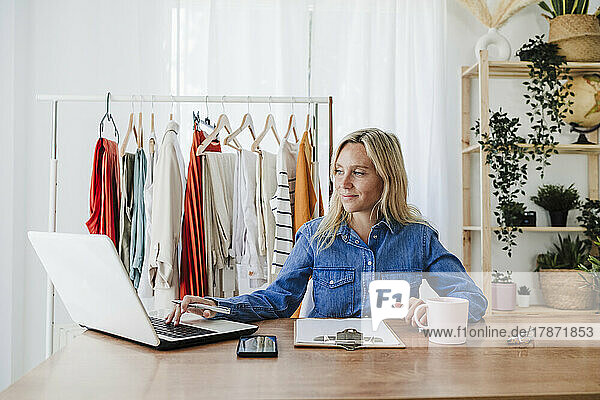 Fashion designer working on laptop at home office