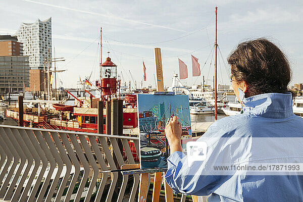 Künstler malt am Hafen an einem sonnigen Tag