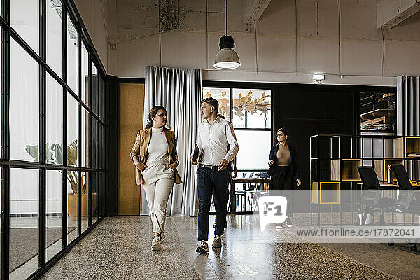 Geschäftskollegen gehen gemeinsam im modernen Büro spazieren