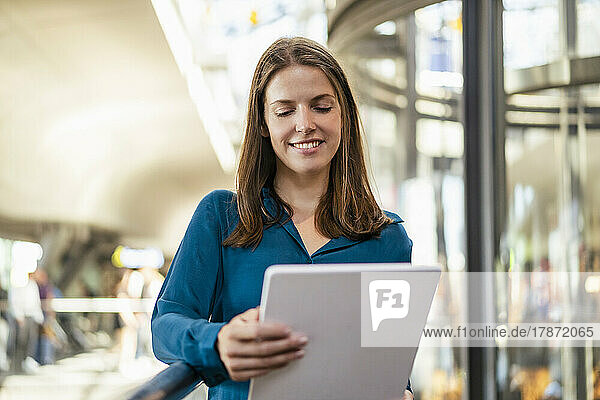 Smiling businesswoman using tablet PC in office
