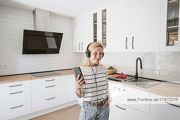 Woman with smart phone listening music through smart phone at home
