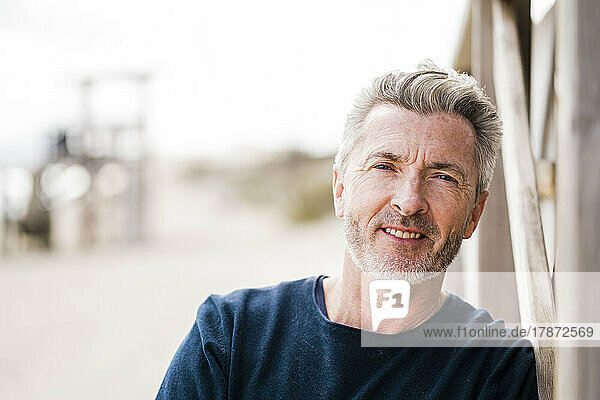 Happy mature man with gray hair at beach