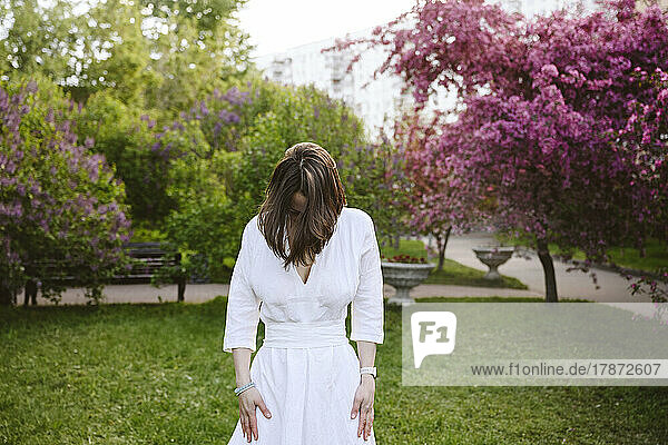 Woman with brown hair standing in garden