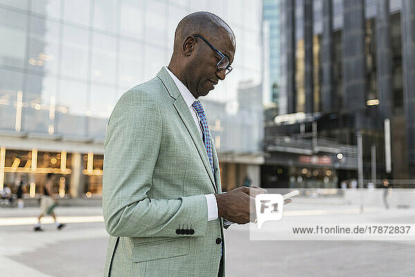 Businessman using mobile phone at financial district