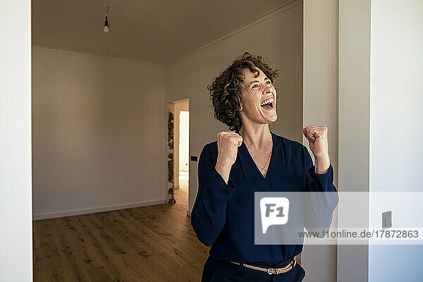 Happy real estate agent clenching fists at new home