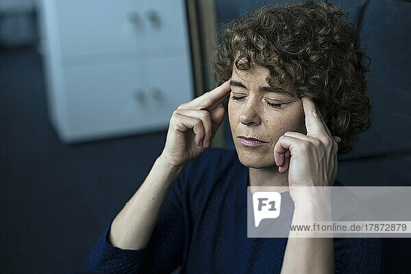 Stressed businesswoman sitting with eyes closed