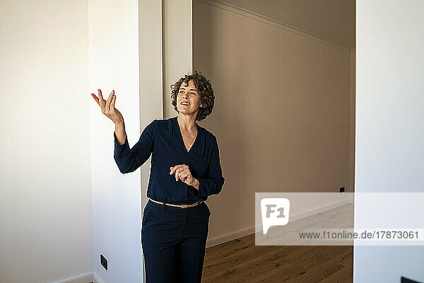 Real estate agent gesturing at doorway of new home