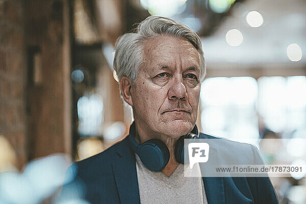 Businessman with wireless headphones at cafe