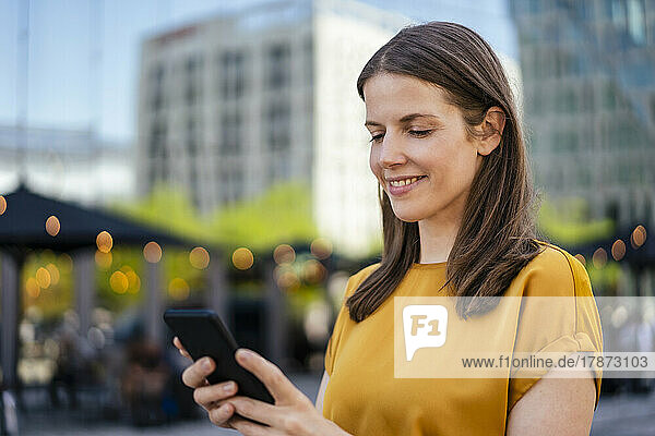 Businesswoman text messaging through smart phone