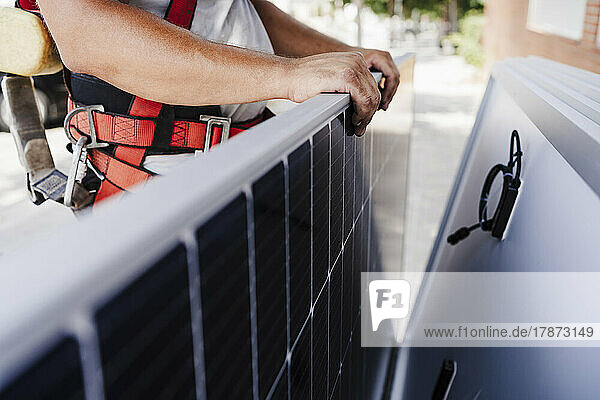 Close-up of electrician holding solar panel