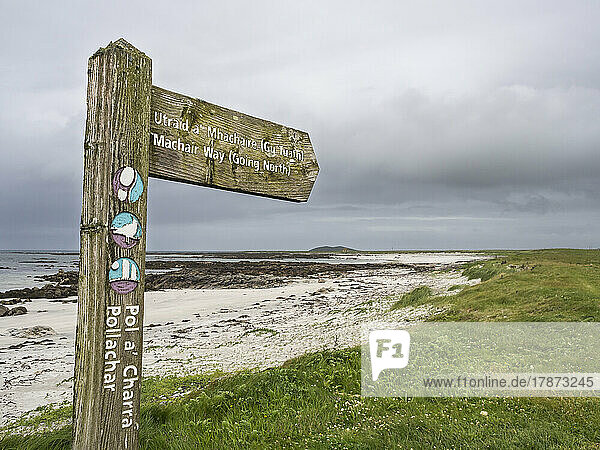 UK  Scotland  Directional sign in front of sandy beach in Outer Hebrides