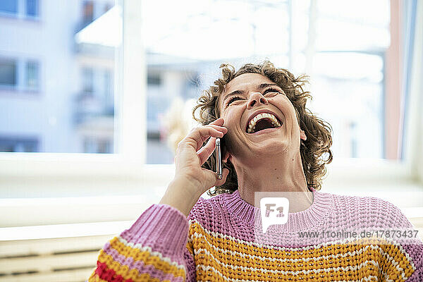 Woman using smart phone laughing at home