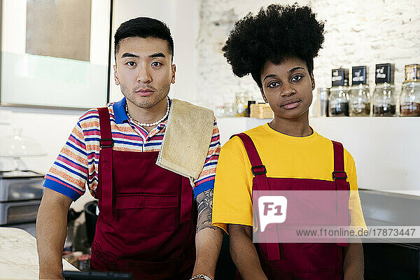 Man and woman wearing aprons in coffee shop