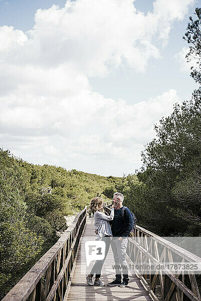 Mature couple standing on footbridge