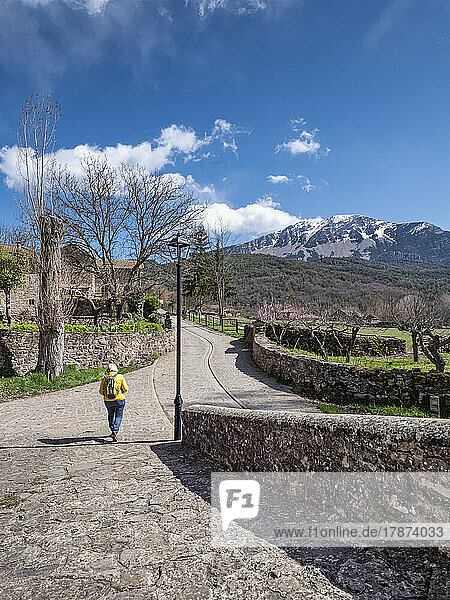 Senior woman walking on footpath with mountain in background