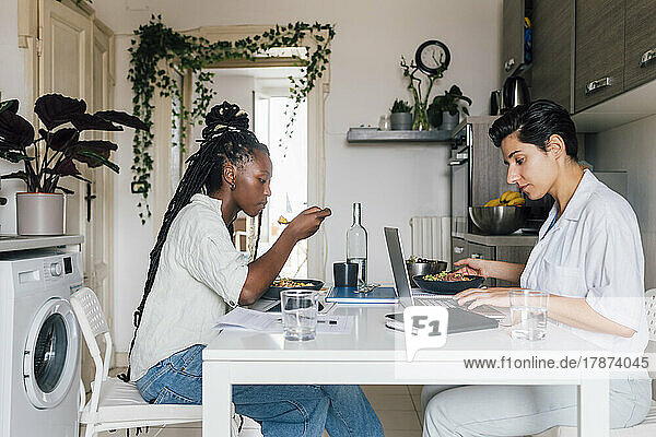 Young businesswomen having breakfast and working at home