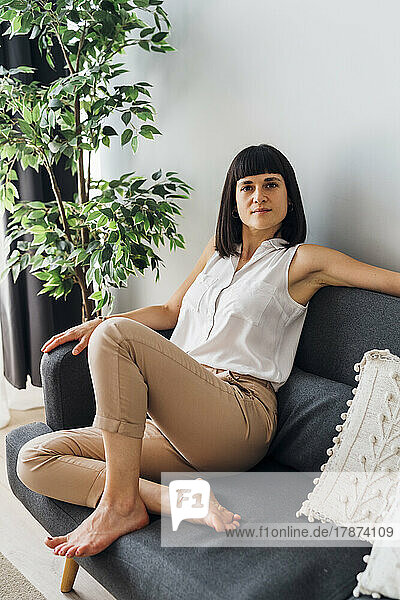 Woman sitting on couch at home