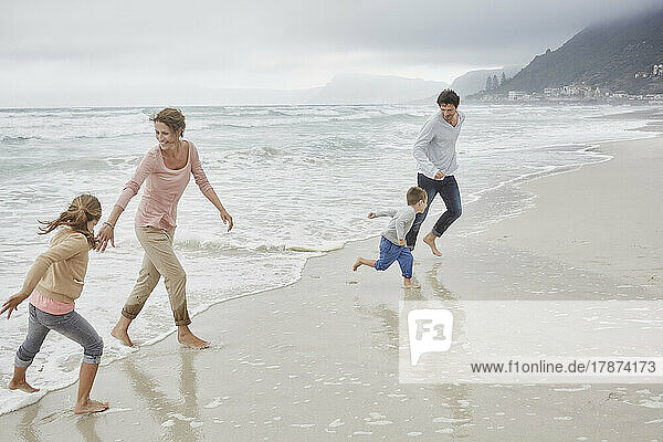 Parents running on the beach with children
