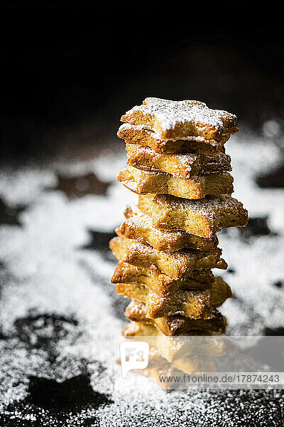 Studio shot of stack of star shaped cookies with powdered sugar