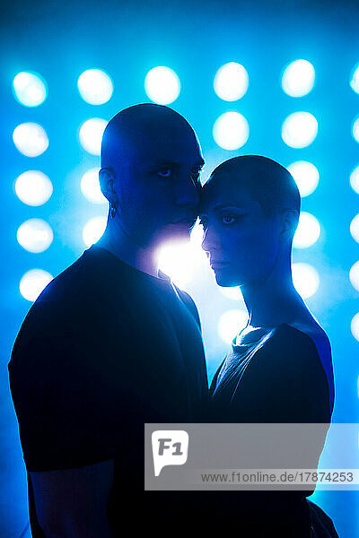 Hipster couple standing in front of glowing lights