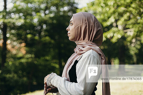 Young woman wearing hijab standing in park
