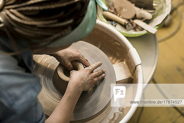 Potter moulding bowl on pottery wheel
