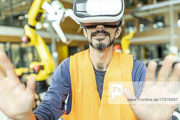 Industrial worker in robotics factory using virtual reality simulator