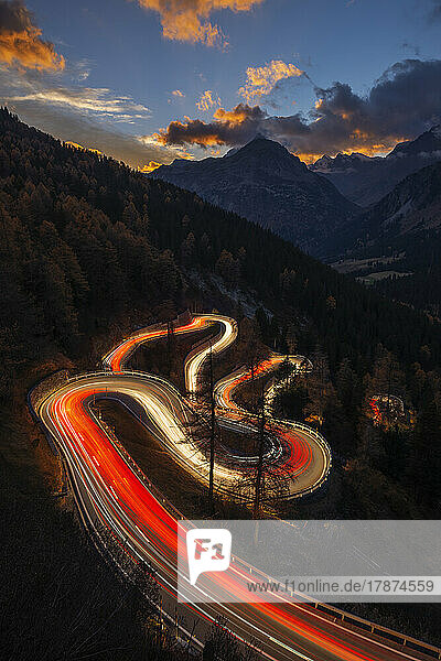 Switzerland  Grisons  Sankt Moritz  Vehicle light trails stretching along Maloja Pass road at dusk
