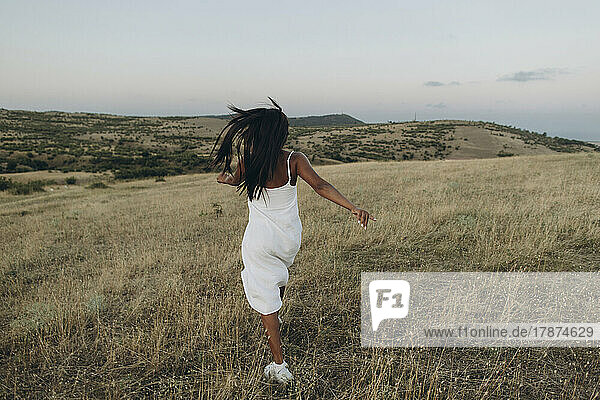 Woman walking in rural meadow