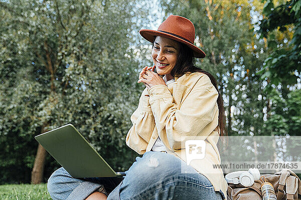 Smiling woman on video call over laptop at park