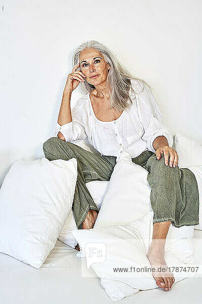 Frau mit grauen Haaren sitzt auf der Couch