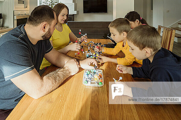 Eltern und Kinder mit molekularen Strukturen auf dem heimischen Tisch
