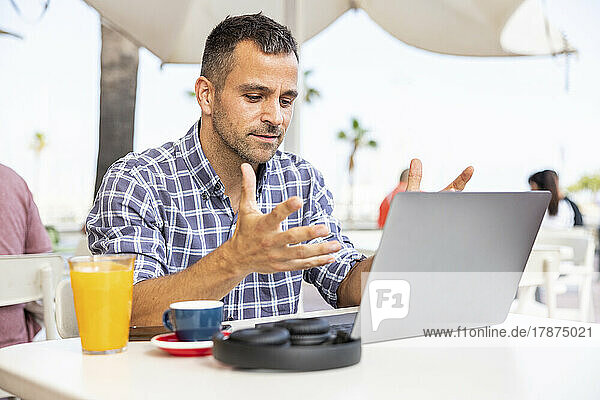 Mature freelancer working on laptop at outdoor cafe