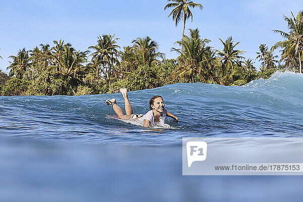 Happy woman enjoying surfing on sea