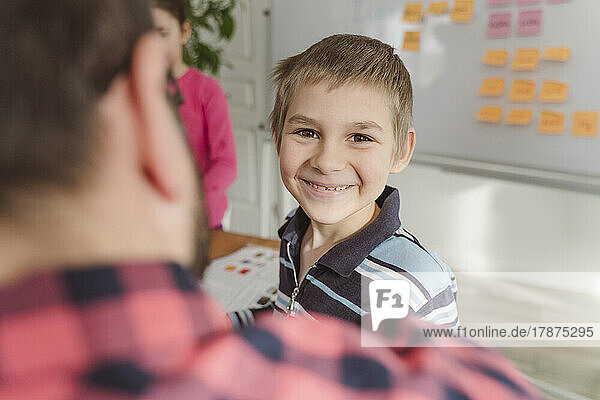 Smiling boy in front of teacher at home