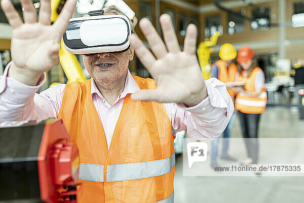 Industrial worker in robotics factory using virtual reality simulator