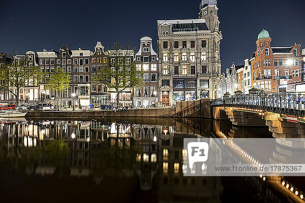 Netherlands  North Holland  Amsterdam  City canal at night with rowhouses in background