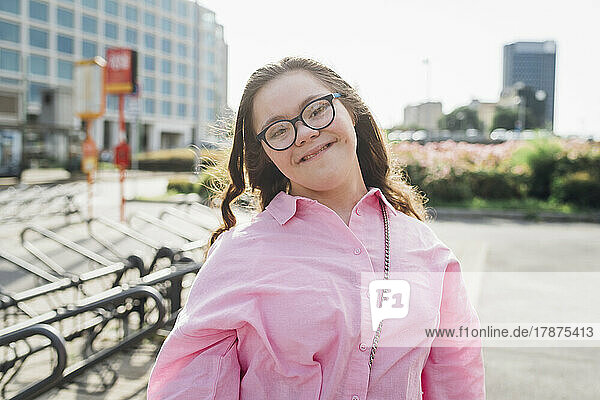 Smiling teenage girl with down syndrome wearing eyeglasses
