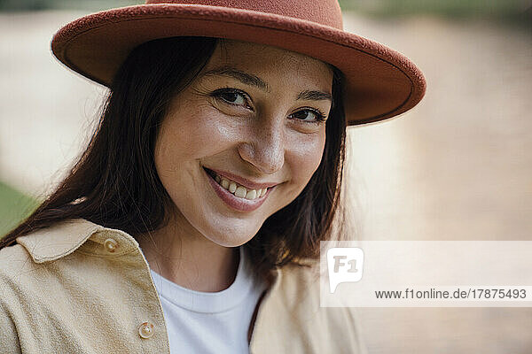 Happy woman wearing hat in park