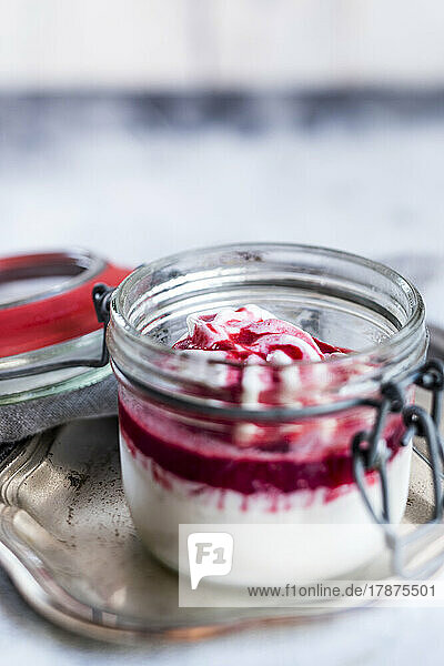 Jar of homemade frozen yogurt with raspberry topping