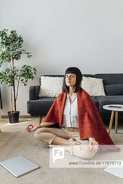 Woman with eyes closed doing yoga at home