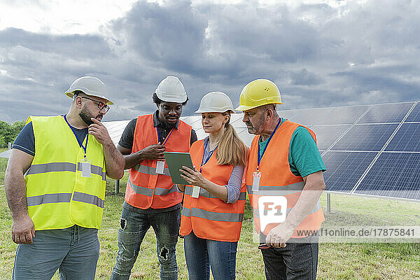 Engineers sharing tablet PC at solar station