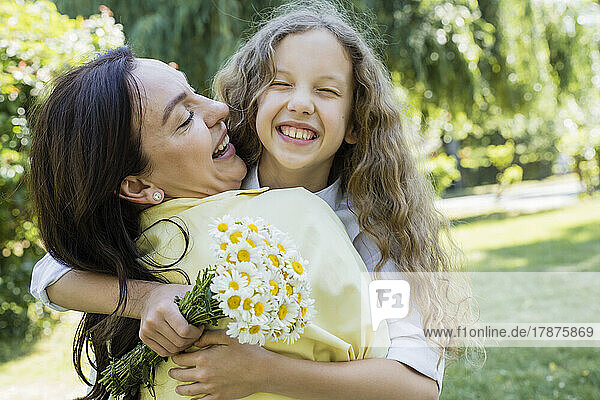 Happy daughter embracing mother at park