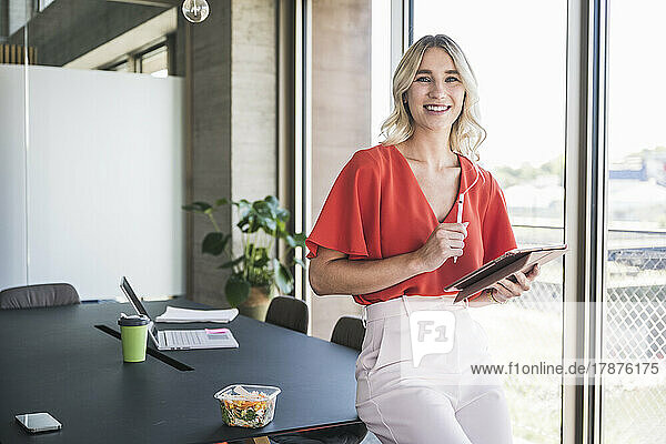 Blond businesswoman with digitized pen and tablet PC in office